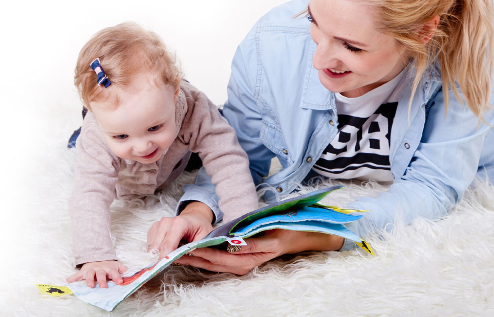 Mutter betrachtet Bilderbuch gemeinsam mit Baby