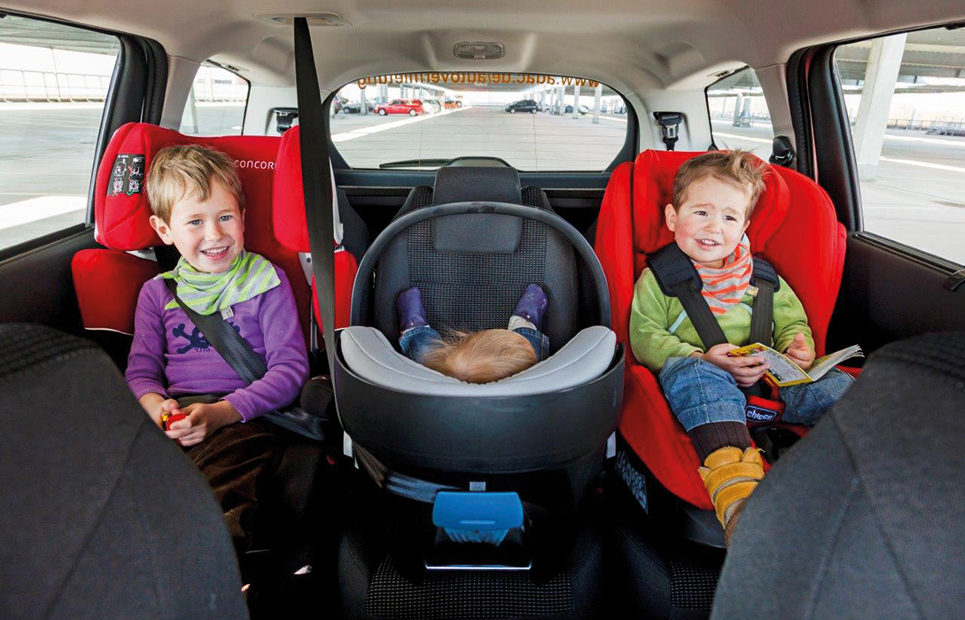 Drei Kinder sitzen in Autokindersitzen