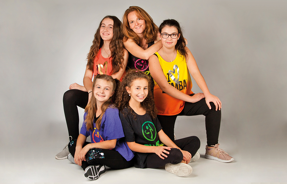 Gruppenfoto von Mädchen in Zumba-Outfits mit Tanztrainerin