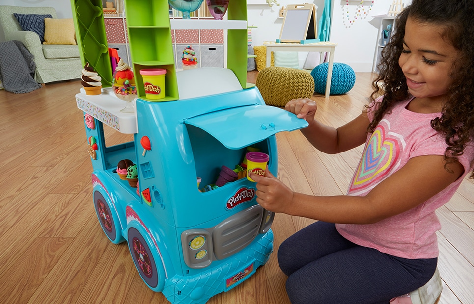 Ein Mädchen spielt mit dem Play-Doh Eiswagen