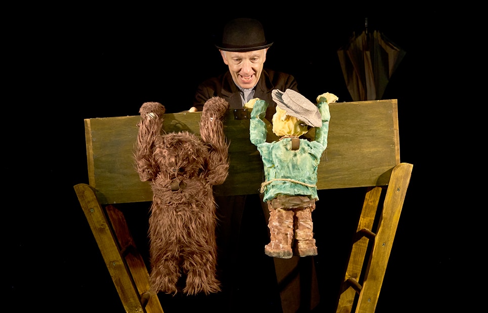 Ein Puppenspiele mit zwei Handpuppen: einem Bär und einem Mann