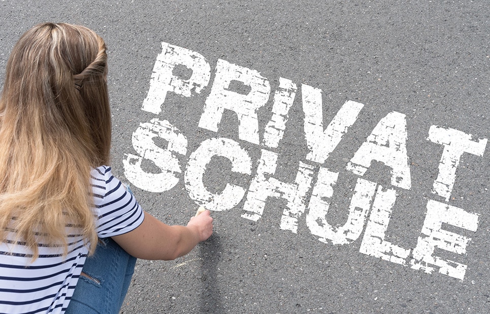 Eine junge Frau schreibt das Wort Privatschule