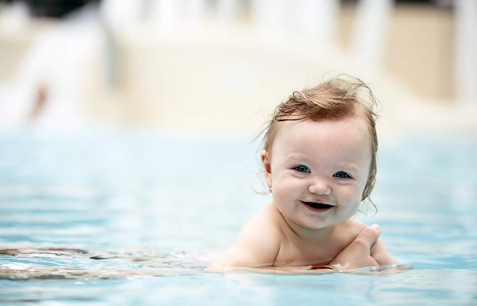 Man sieht ein Baby beim Babyschwimmen.